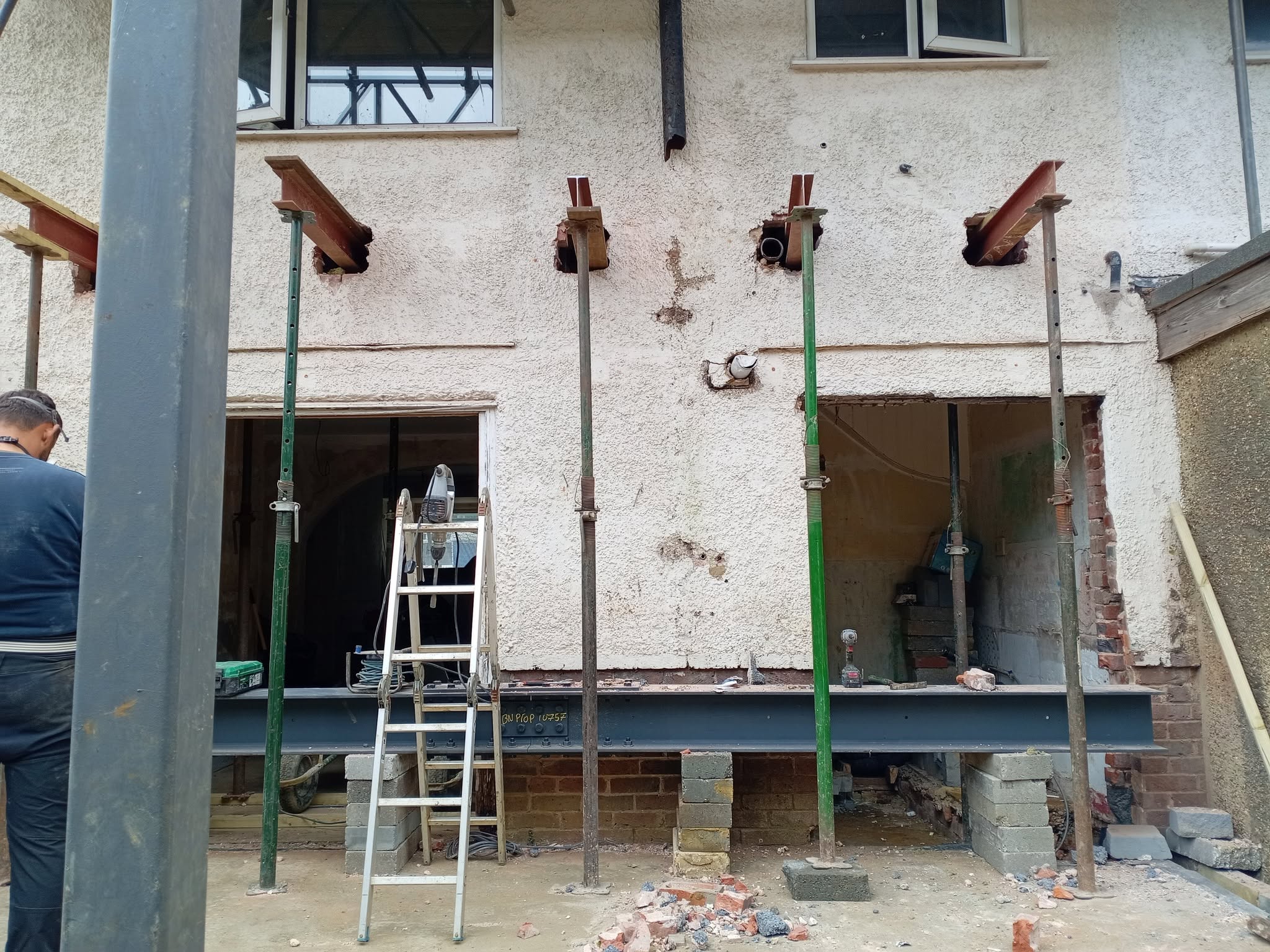 Structural steel beam and acro props installed during a load-bearing alteration
